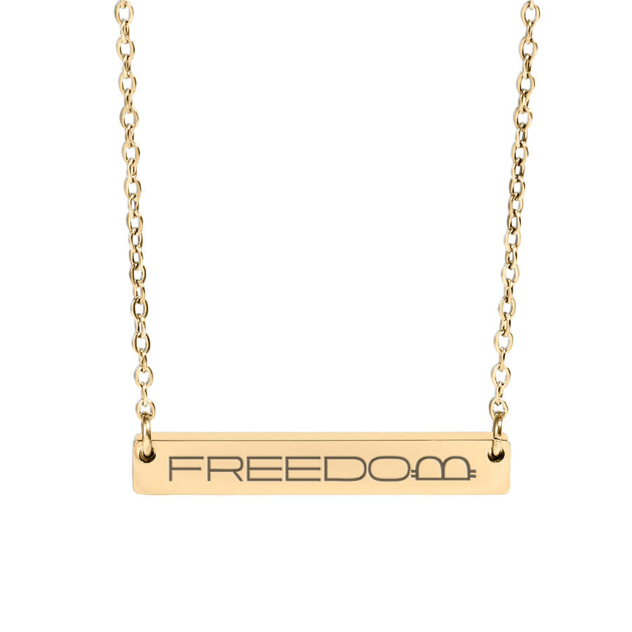 Gold necklace with 'FREEDOM' pendant on a white background