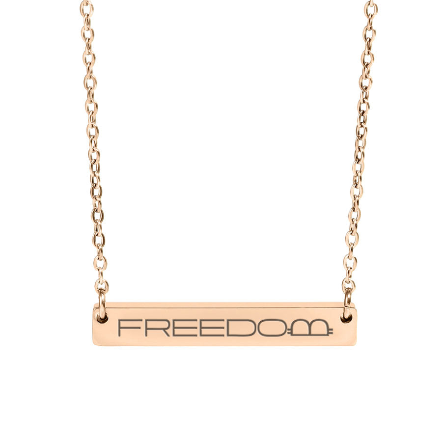 Rose gold necklace with 'FREEDOM' pendant on a white background