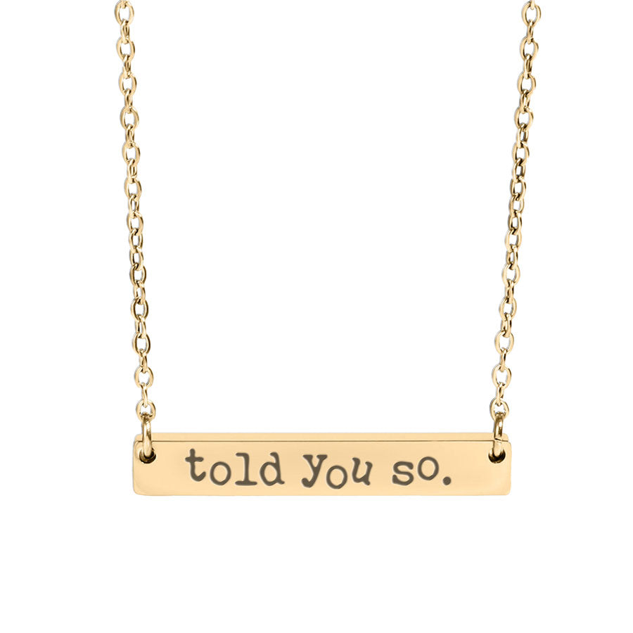 Gold necklace with 'told you so' pendant on a white background