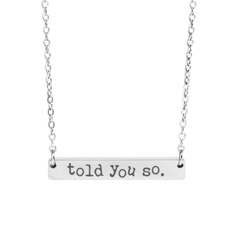 Silver necklace with 'told you so' pendant on a white background
