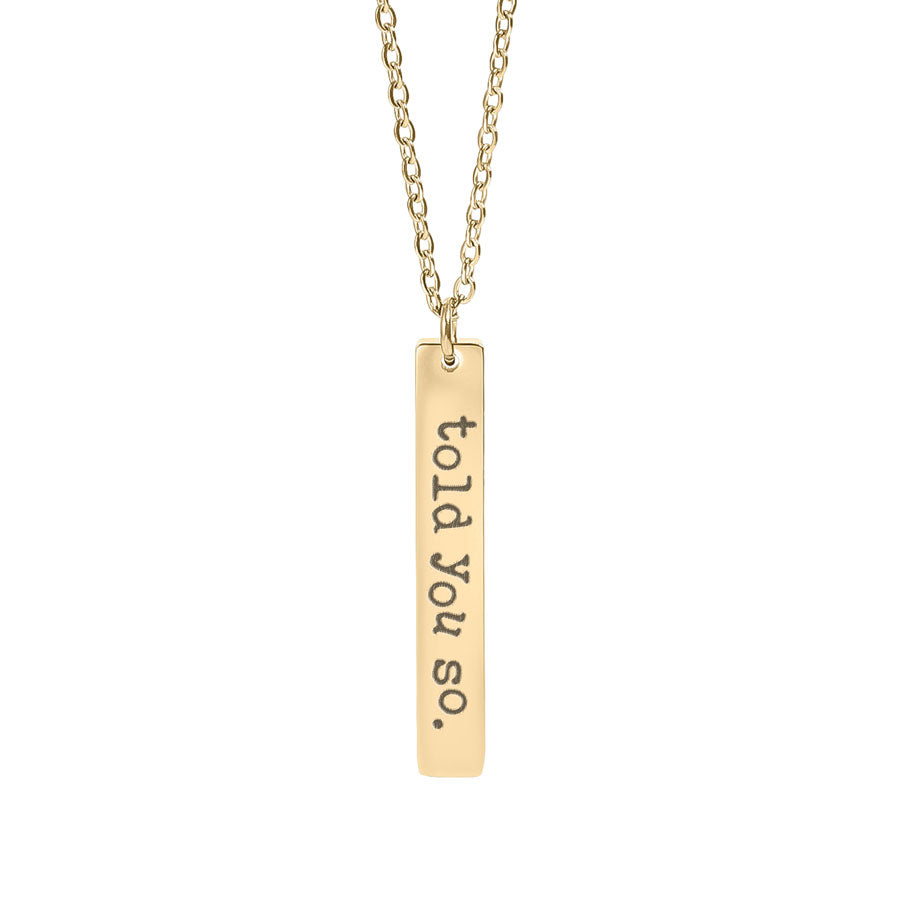 Gold necklace with a bar pendant that reads 'told you so.' on a white background