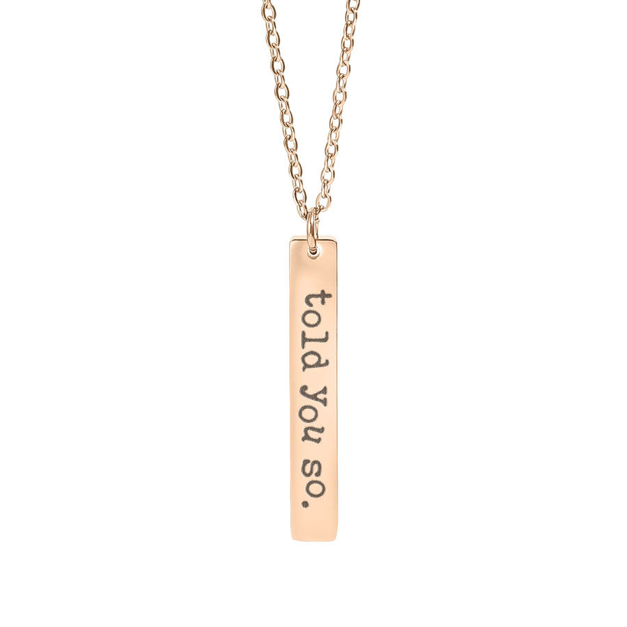 Rose gold necklace with a bar pendant engraved 'told you so.' on a white background