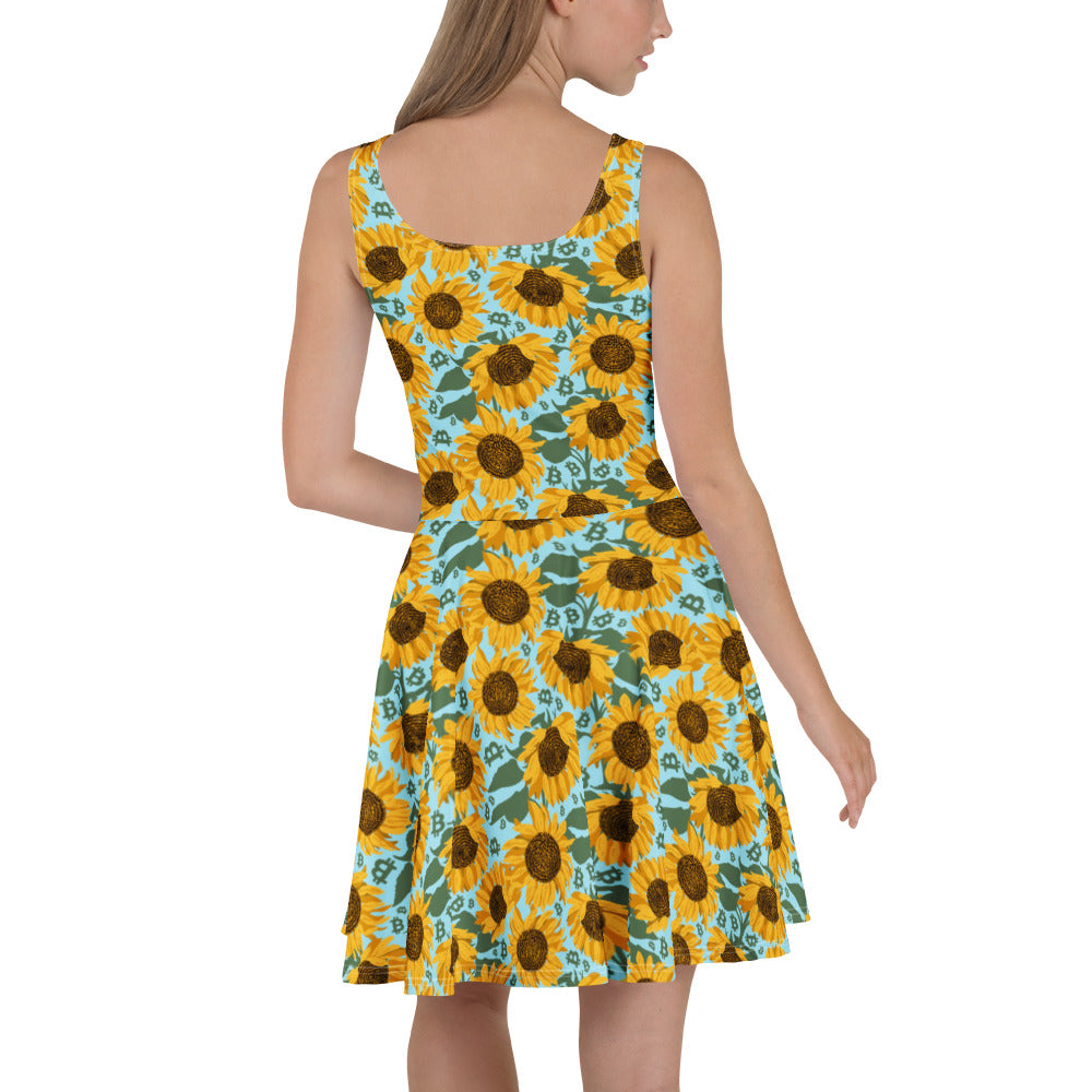 Woman wearing a sleeveless dress with sunflower and bitcoin pattern on a white background