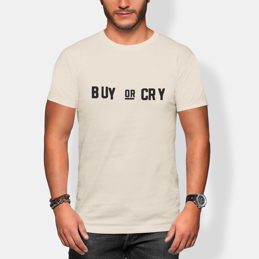 Man wearing a beige t-shirt with 'BUY OR CR Y' text on a plain background