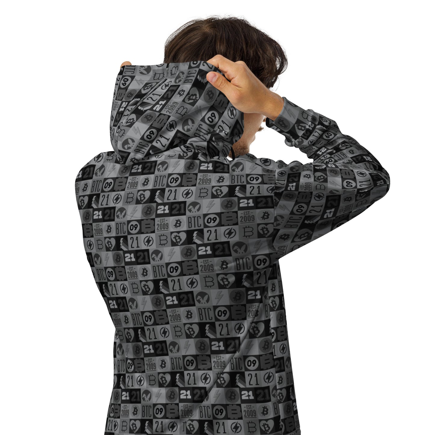 Person wearing a black and gray bitcoin patterned hoodie with the hood up, on a white background
