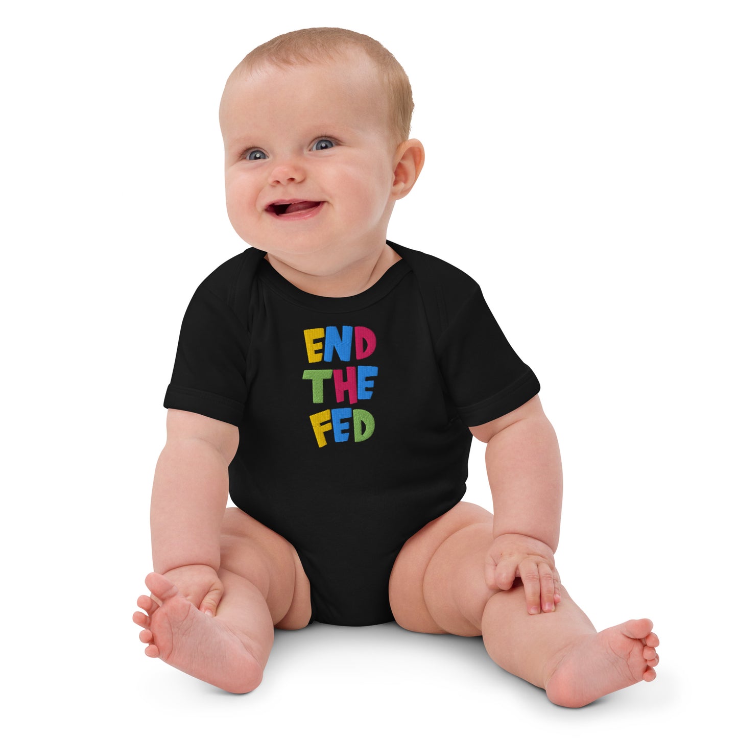 Baby wearing a black onesie with colorful 'end the fed' text on a white background