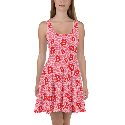 Woman wearing a pink dress with red bitcoin and hearts pattern on a white background