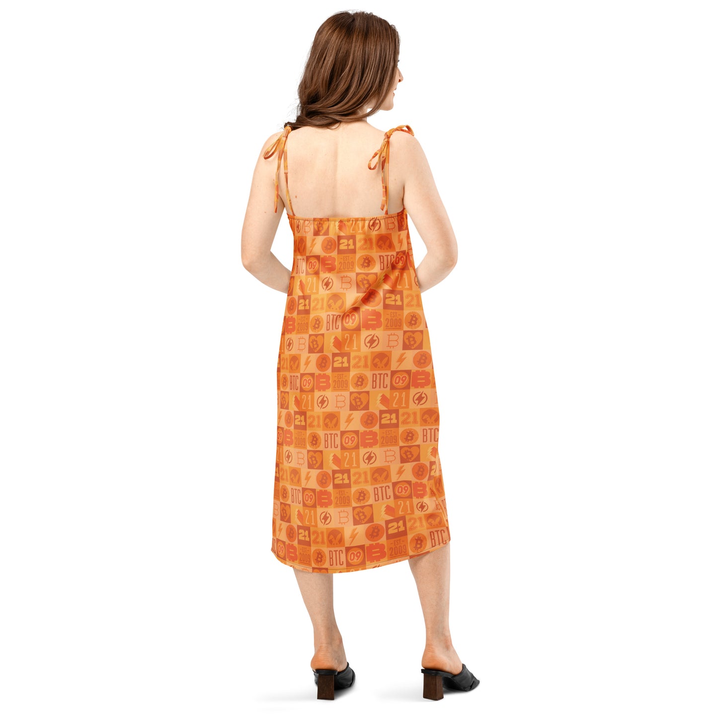 Woman wearing an orange bitcoin patterned dress on a white background