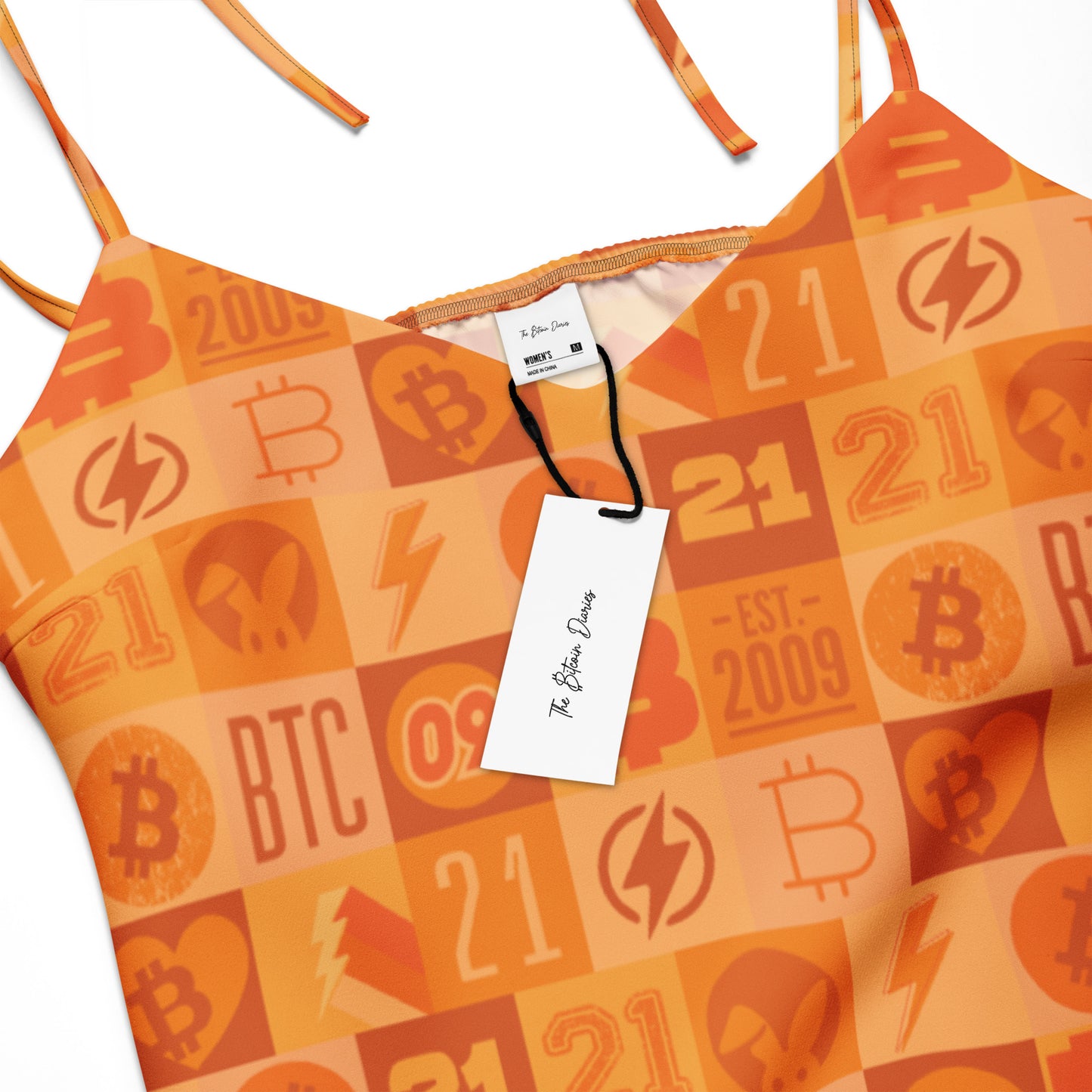 Orange dress with Bitcoin-themed design and visible brand tag on a white background