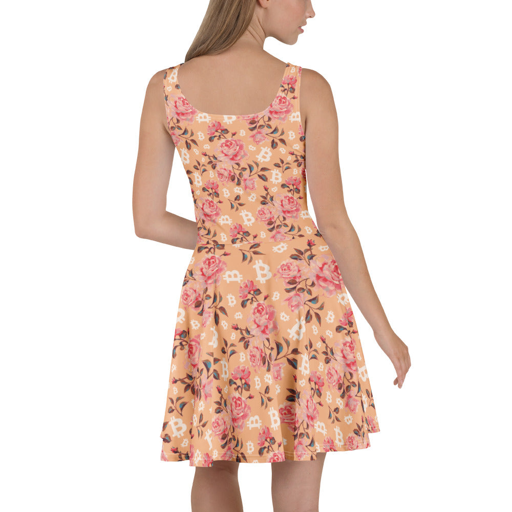 Woman wearing a peach floral dress with bitcoin symbols on a white background