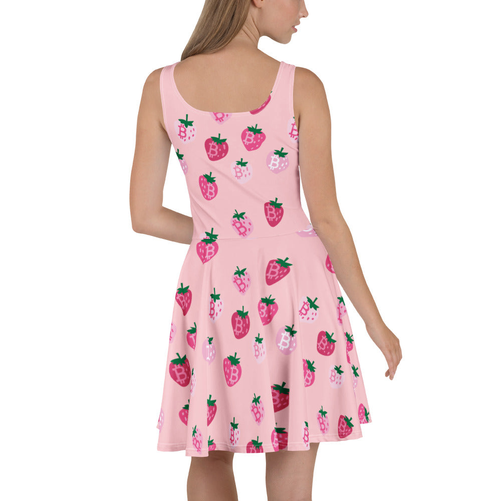 Pink dress with strawberry bitcoin pattern worn by a model on a white background