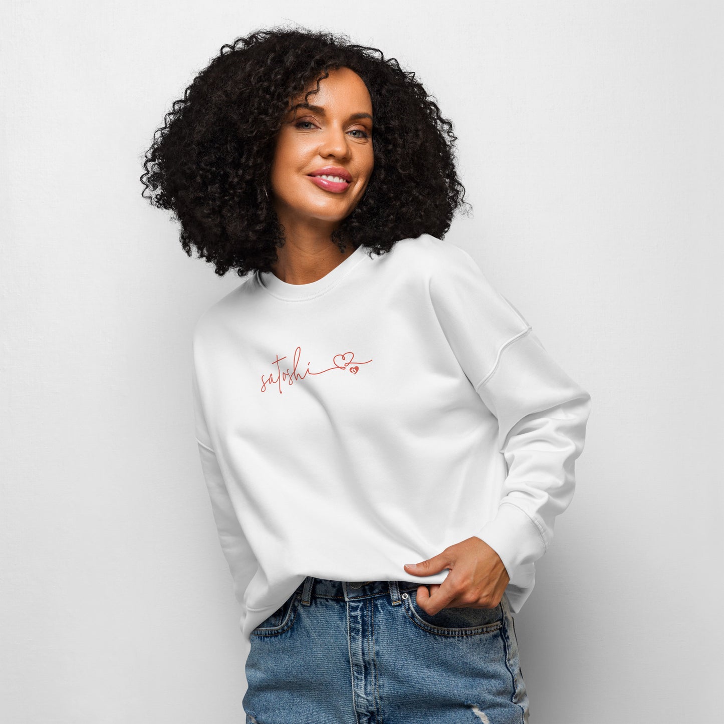 Woman wearing a white sweatshirt with satoshi text on a plain background