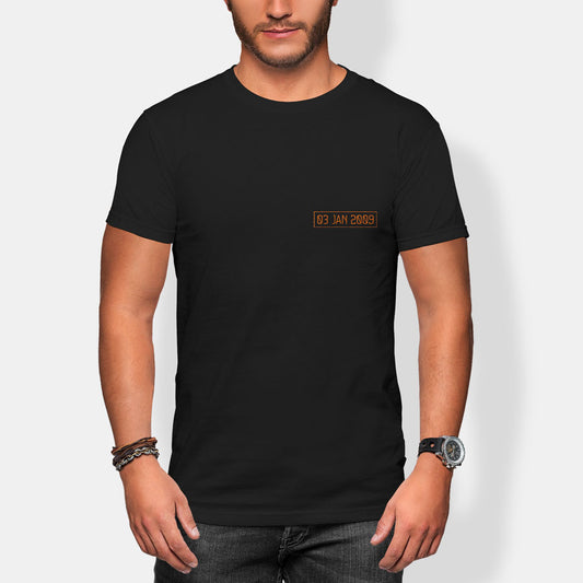 Person wearing a black t-shirt with a small 03 jan 2009 text print on a plain background