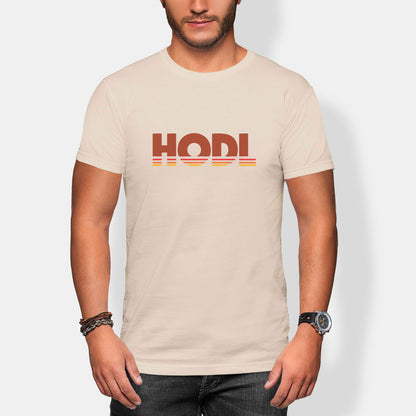 Man wearing a beige t-shirt with 'HODL' printed on it against a plain background