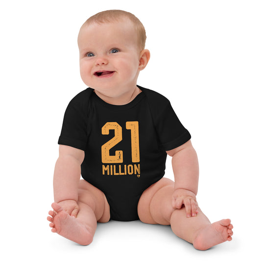 Baby wearing a black onesie with '21 MILLION' printed in gold on a white background