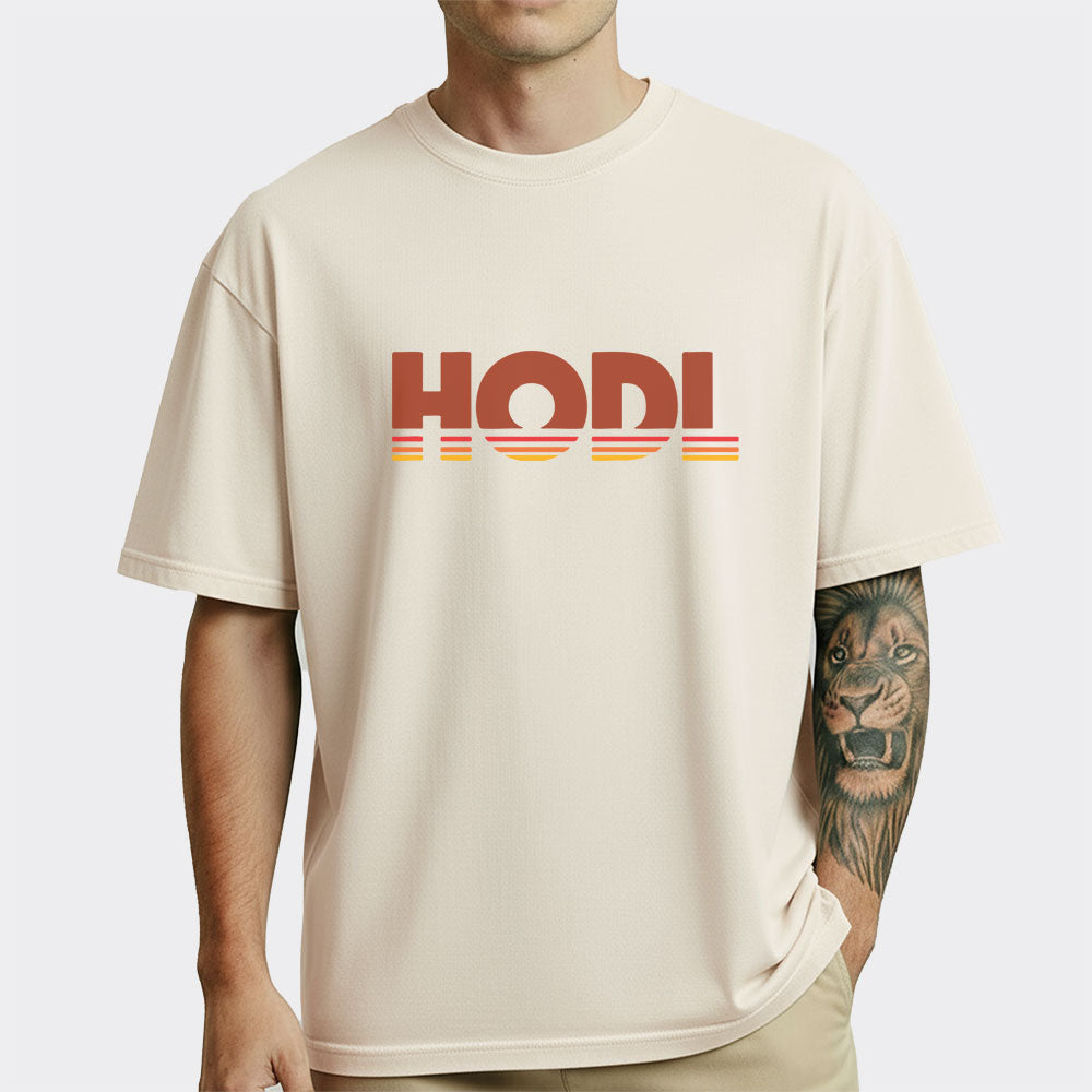 Person wearing a beige t-shirt with 'HODL' printed on it against a white background