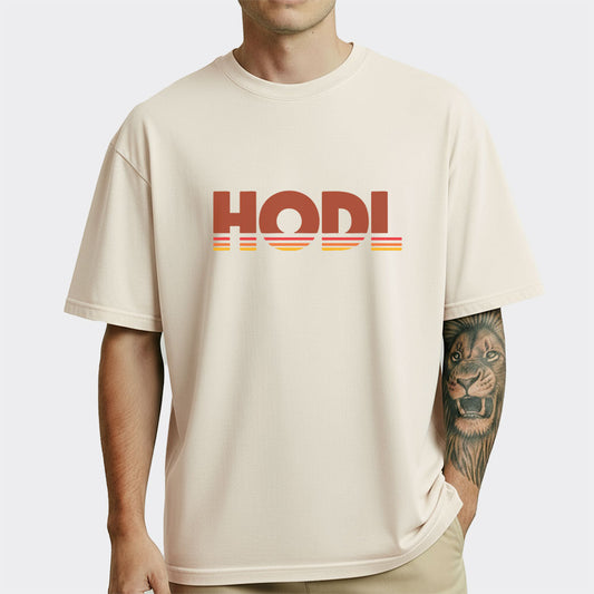 Person wearing a beige t-shirt with 'HODL' printed on it against a white background
