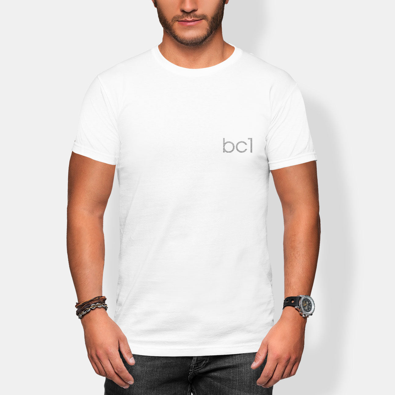 Man wearing a white t-shirt with 'bc1' logo on a plain background