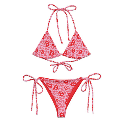 Red and pink bikini set with letter 'B' bitcoin and hearts pattern on a white background