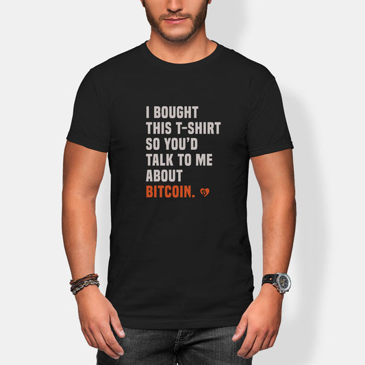 Person wearing a black t-shirt with Bitcoin-themed text 'i bought this shirt so you'd talk to me about bitcoin' on a white background