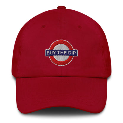 Red cap with 'BUY THE DIP' logo on a white background