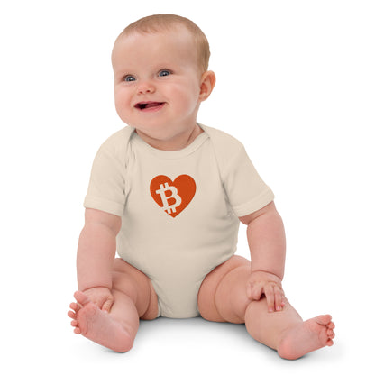 Baby wearing a onesie with a heart-shaped Bitcoin logo on a white background