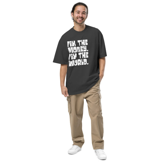 Man wearing a black t-shirt with fix the money fix the world text and beige pants on a white background
