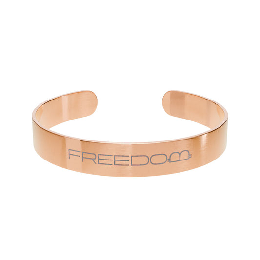 Rose gold bracelet with 'FREEDOM' engraving on a white background