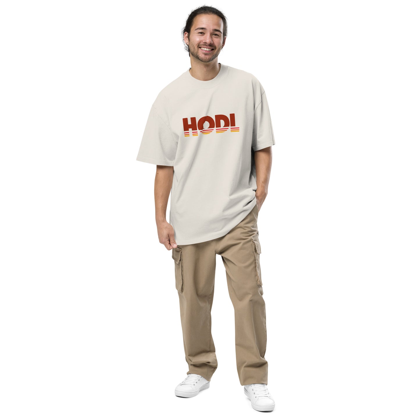 Man wearing a beige t-shirt with 'HODL' logo and beige pants on a white background
