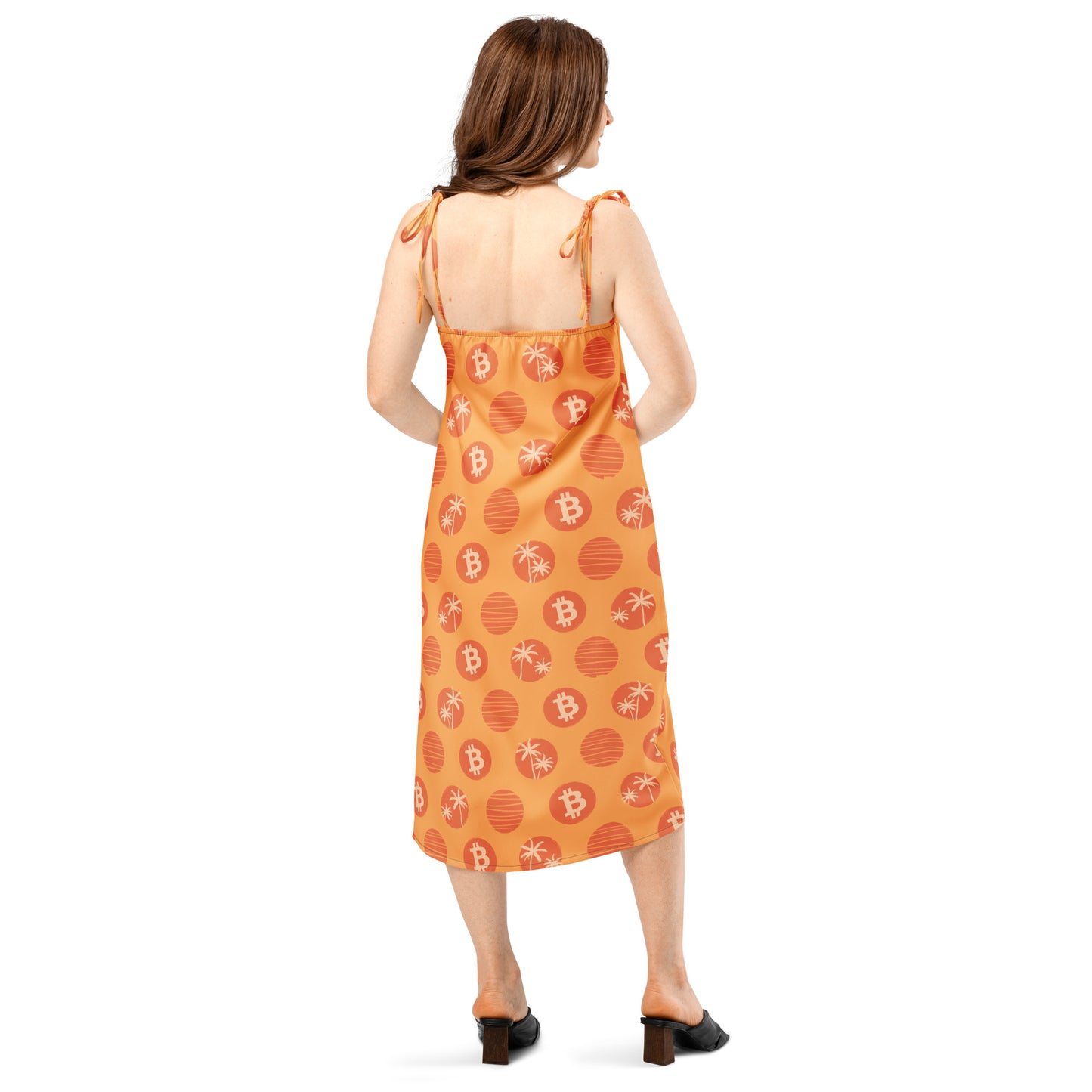Woman wearing an orange dress with bitcoin tropical patterns on a white background