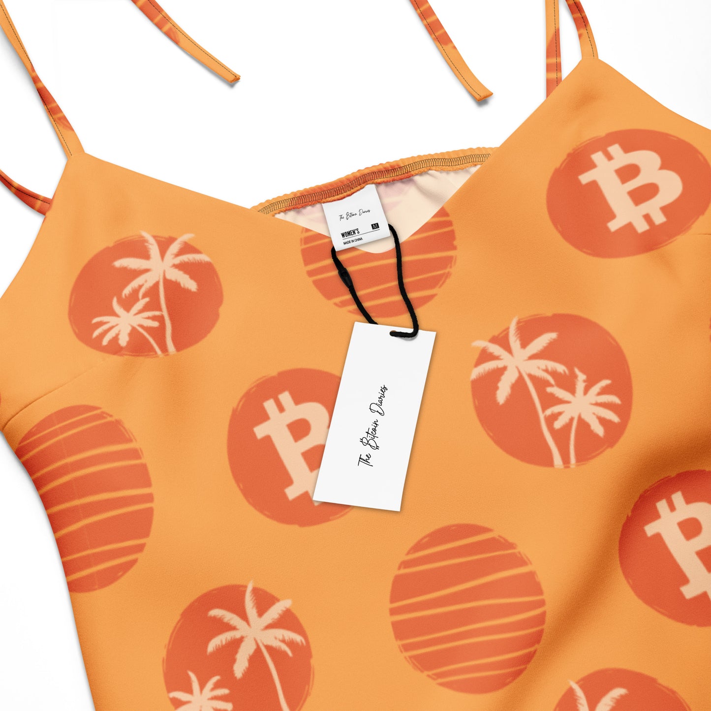 Orange dress with Bitcoin and palm tree patterns and a tag on a white background